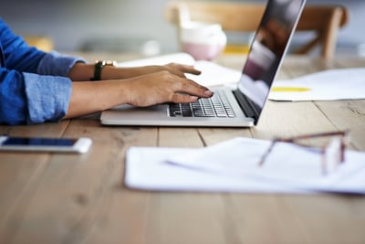 Woman writing blog posts on laptop